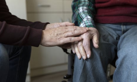 a person holds an older person's hand