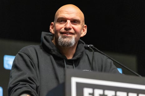 John Fetterman stands at a microphone on a podium.