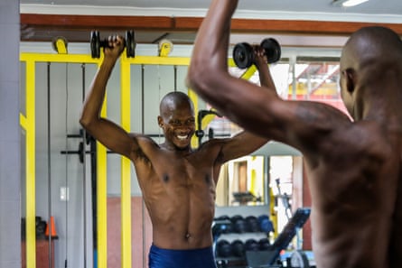 Luvo Manyonga lifts weights in front of a mirror