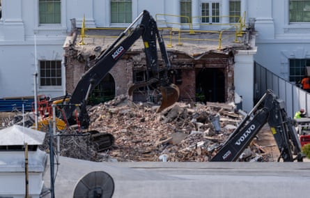 An excavator clearns rubble after the East Wing of the White House was demolished
