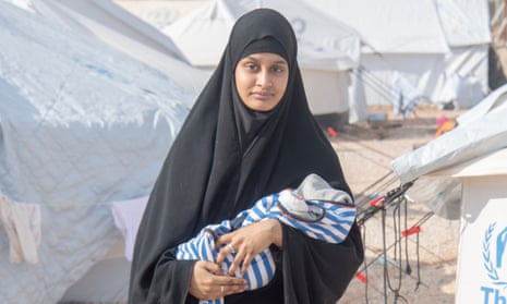 Begum holding her newborn baby in Syria, 2019.