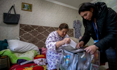 O femeie în vârstă își votează din ceea ce pare a fi patul ei