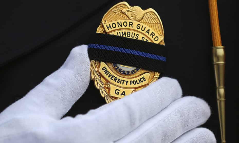 An officer wears black over his badge in honor of a colleague killed responding to a domestic dispute in Americas, Georgia on 11 December 2016.