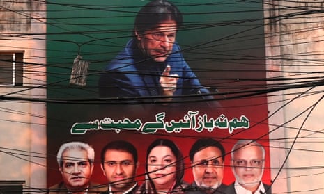 A poster of Pakistan's ex-prime minister Imran Khan is seen through cables in Lahore