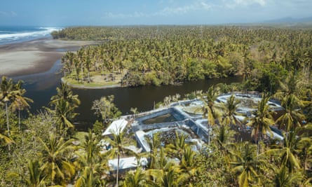 An aerial view of a prawn farm on the coastline of a tropical island