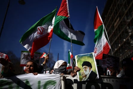 Protesters hold an image of Ali Khamenei at a rally calling for the end of the bombardment of Iran