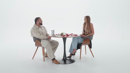 A man and woman sitting at a table in a white room