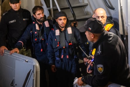 Four rescued sailors on a boat.