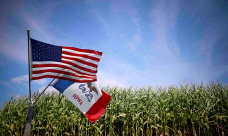 US and Iowa state flags fly next to a corn field in Grand Mound, Iowa.