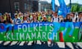 People march behind a banner reading 'people's climate march' in Danish