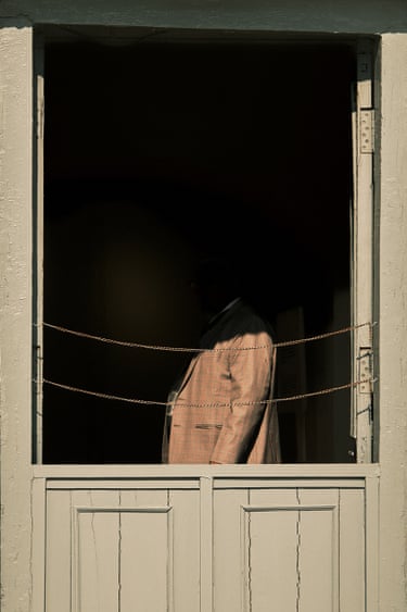 A brown-coated figure in shadow