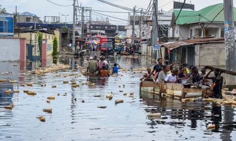 People in makeshift boats in a heavily flooded area of Kinshasa