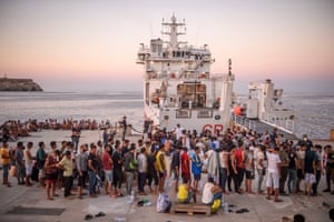 Migrants wait to board the coastguard ship Diciotti before being transferred to Porto Empedocle from Lampedusa
