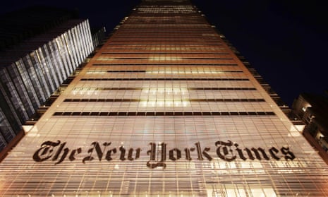 Taken at night from street level, looking up the brightly lit face of a skyscraper, in amber tones, with the New York Times logo in large letters across perhaps the third floor.