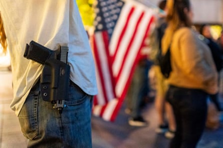 a person with a gun in pocket next to an American flag