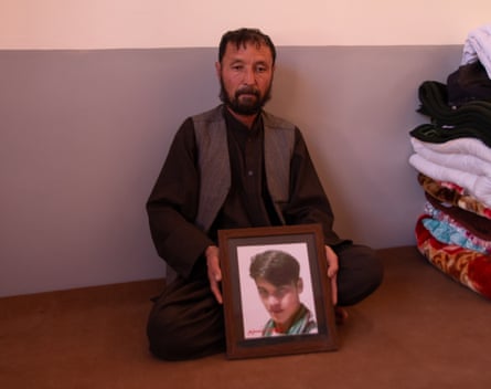 Abdul Rahim, from Daykundi in Afghanistan, holds a picture of his 22-year-old son Nasim, another victim of the Mach massacre.