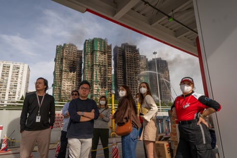 People look on as the blaze burns through Wang Fuk Court residential estate. Residential buildings continue to burn at Wang Fuk Court in the Tai Po district of Hong Kong. At least 50 people are confirmed dead and hundreds are still missing following a high-rise apartment fire at Wang Fuk Court in Tai Po district which was started on Wednesday afternoon. Major fire kills at least 50 in Hong Kong, China - 27 Nov 2025