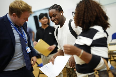 A student smiles while opening their GCSE results.