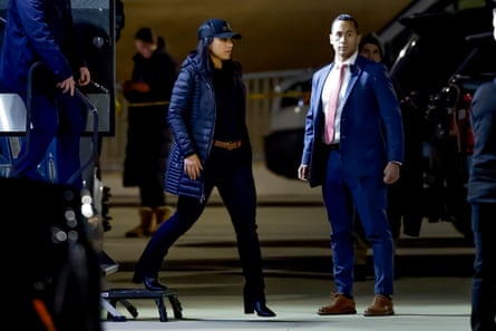 A woman walks outside between people