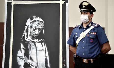 A member of Italy’s carabinieri stands alongside the recovered mural