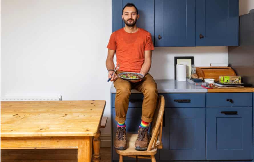 Faraj Alnasser in kitchen, holding a bowl of his winter tabbouleh