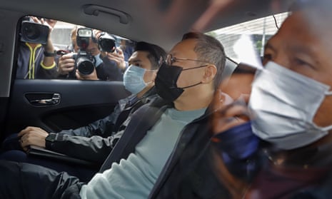 The legal scholar Benny Tai (C), is driven away in a car after he was among those arrested
