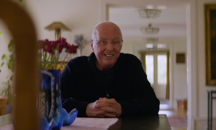 Sven-Göran Eriksson sitting at a table in house, with flowers behind him