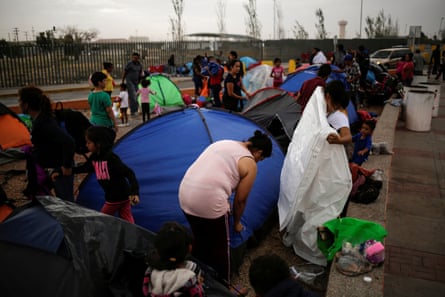 Mexicans camping near the Santa Fe international border crossing bridge while waiting to apply for asylum arrange their belongings as they are moved to a shelter due a storm forecast, in Ciudad Juárez, Mexico.