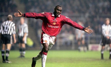 Andy Cole celebrates while Newcastle stand shocked after their former player scored a goal.