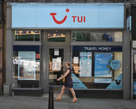 A woman passes a closed shop of travel company Tui in Halifax