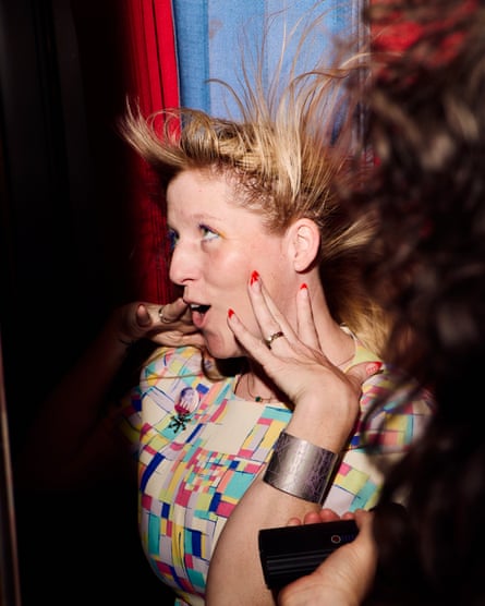 a woman takes a photo in one of the analog photo booths