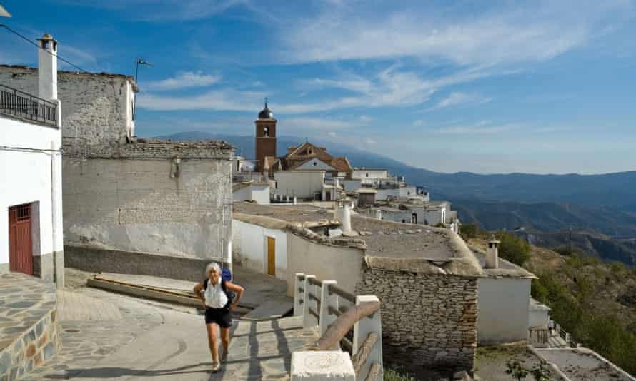 An woman with backpack walks in the Spanish village of Laroles in the Alpujarras