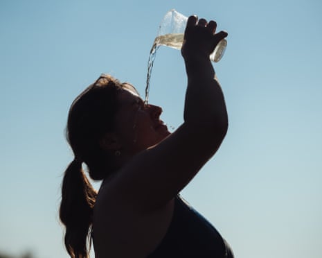 A woman pours a cup of cold water on her face as she cools of in the Tisza River near the village of Male Trakany, eastern Slovakia