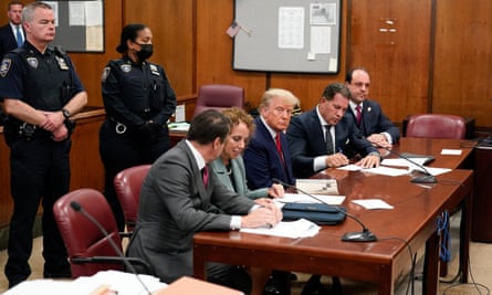 Trump, center, appears in court for his arraignment on 4 April 2023, in New York.