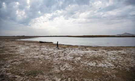 A person walks on a dried-up river bed.