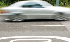 A car speeding past a '40' mph highway code sign painted on the tarmac