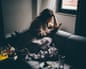 Sad and depressed woman using smartphone at home