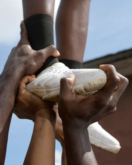Close-up of the hands of Lagos Cheer Nigeria cheerleading team members holding the feet of another member they are holding up