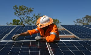 A Northern Territory worker installs solar panels