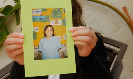 woman holds childhood picture of herself
