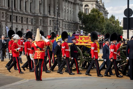 The Queen’s coffin enters the gates to the Palace of Westminster alongside the Queen’s Guards.