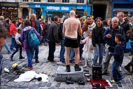 Performer Living Space receives his just rewards after his show on the Royal Mile.