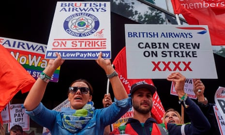 Demonstrators hold placards as they protest in London  over British Airways mixed fleet cabin crew pay