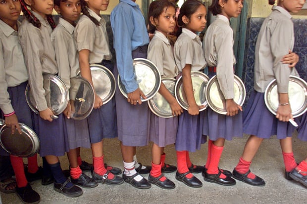 Young students lining up in a row with a metal plate.