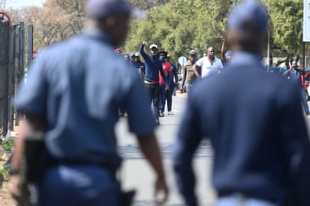 Policemen watch demonstrators