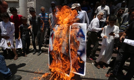 Palestinians burn a poster of Donald Trump