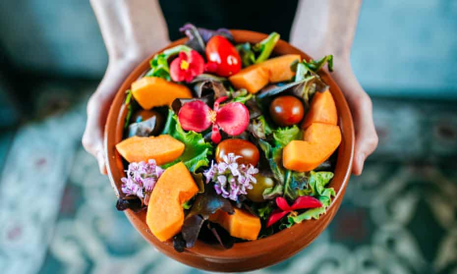 Bowl of salad garnished with edible flowers