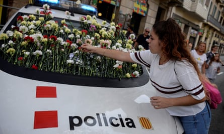 A woman puts a flower on a Catalan police car during a pro-independence referendum rally in Barcelona