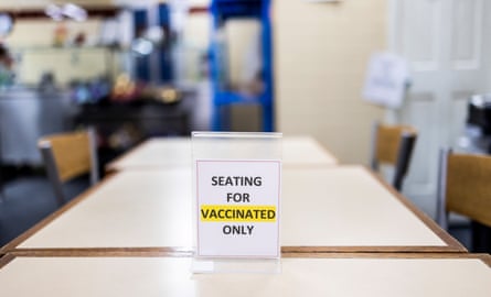 A sign on a table in a restaurant reads “Seating for vaccinated only.”