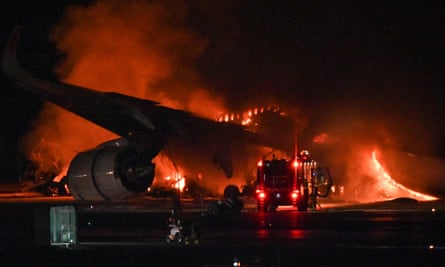 The Japan Airlines passenger plane on fire on the tarmac at Haneda airport.